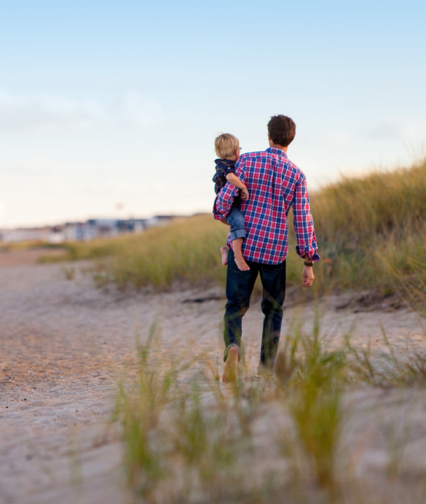 Man Walking with Child on Beach